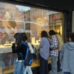 أشخاص يقفون أمام واجهة متجر ساعات سويسرية فاخرة من علامة أوميغا (Omega)