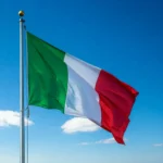 علم إيطاليا يرفرف بفخر تحت السماء الزرقاء، يعكس التاريخ والحضارة الإيطالية العريقة.