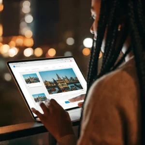 اعرف طرق الربح من الصور امرأة تبيع صورًا رقمية عبر الإنترنت للتنزيل. واجهة موقع الويب مرئية في المقدمة ، والخلية عبارة عن ضباب من أضواء المدينة.