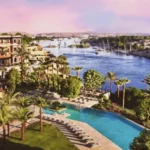 صورة مذهلة تظهر فندق كتاراكت في أسوان، مصر، أحد فنادق سوفيتيل النيل، محاطًا بمناظر طبيعية خلابة على ضفاف النيل. يُعد هذا الفندق وجهة سياحية مثالية في الشتاء بأجوائه الدافئة وأسعاره المناسبة.