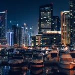 إطلالة ليلية على مرسى دبي مع الأضواء المتلألئة واليخوت الراسية أمام الأبراج الشاهقة.